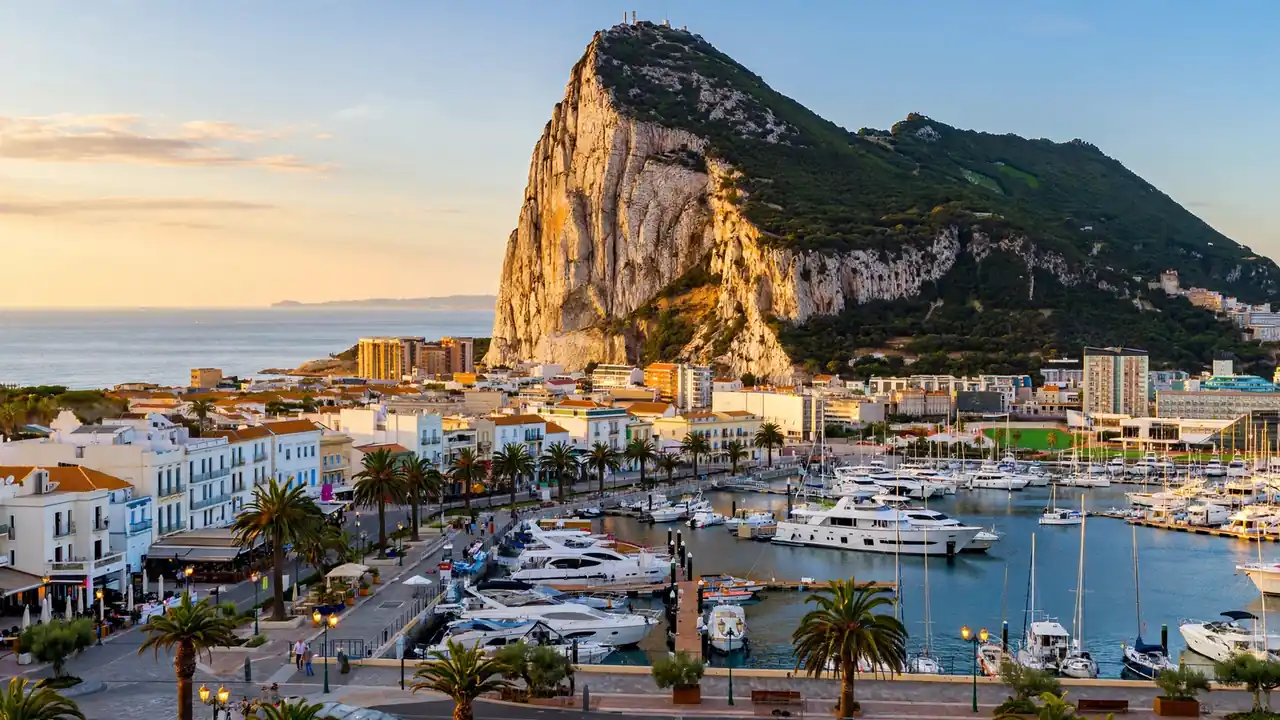 Rock of Gibraltar rising over the Mediterranean town and marina below